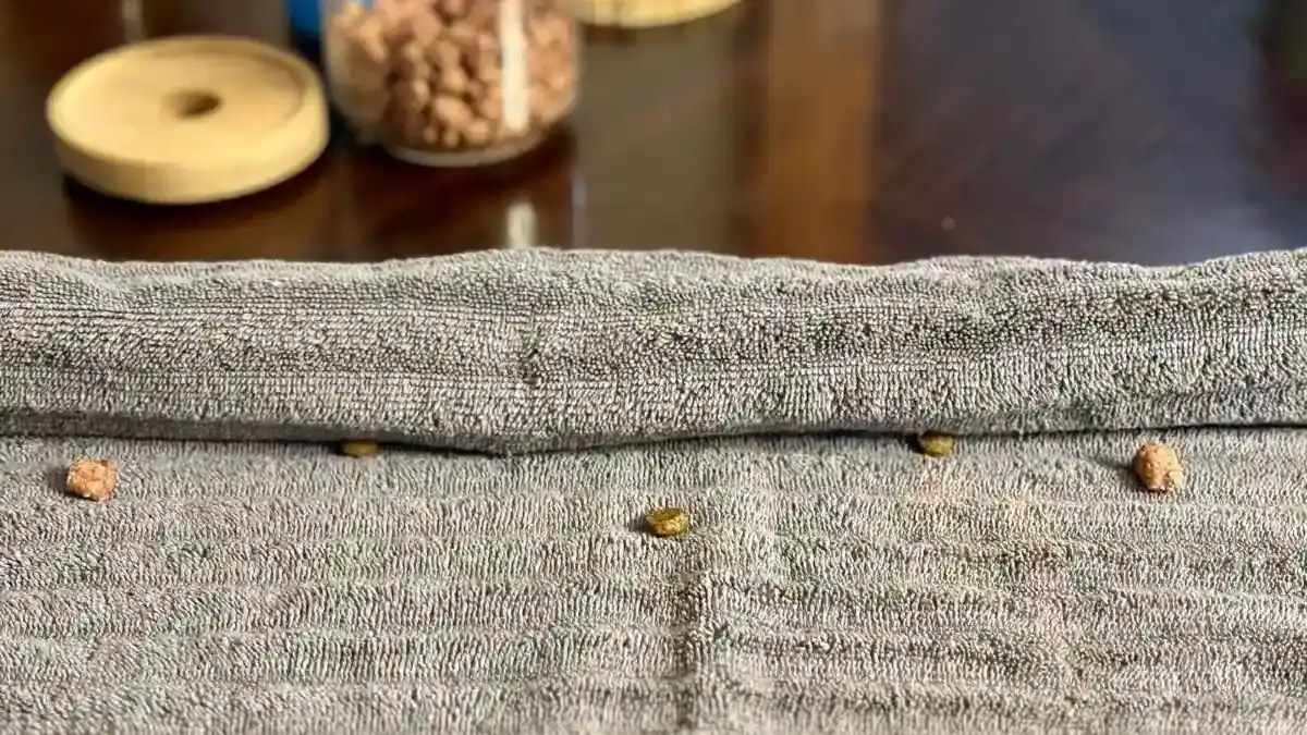 Towel puzzle with kibble wrapped in a grey towel